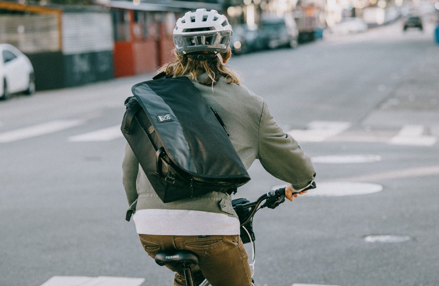 Un homme porte un sac en bandoulière dans le dos en vélotaf