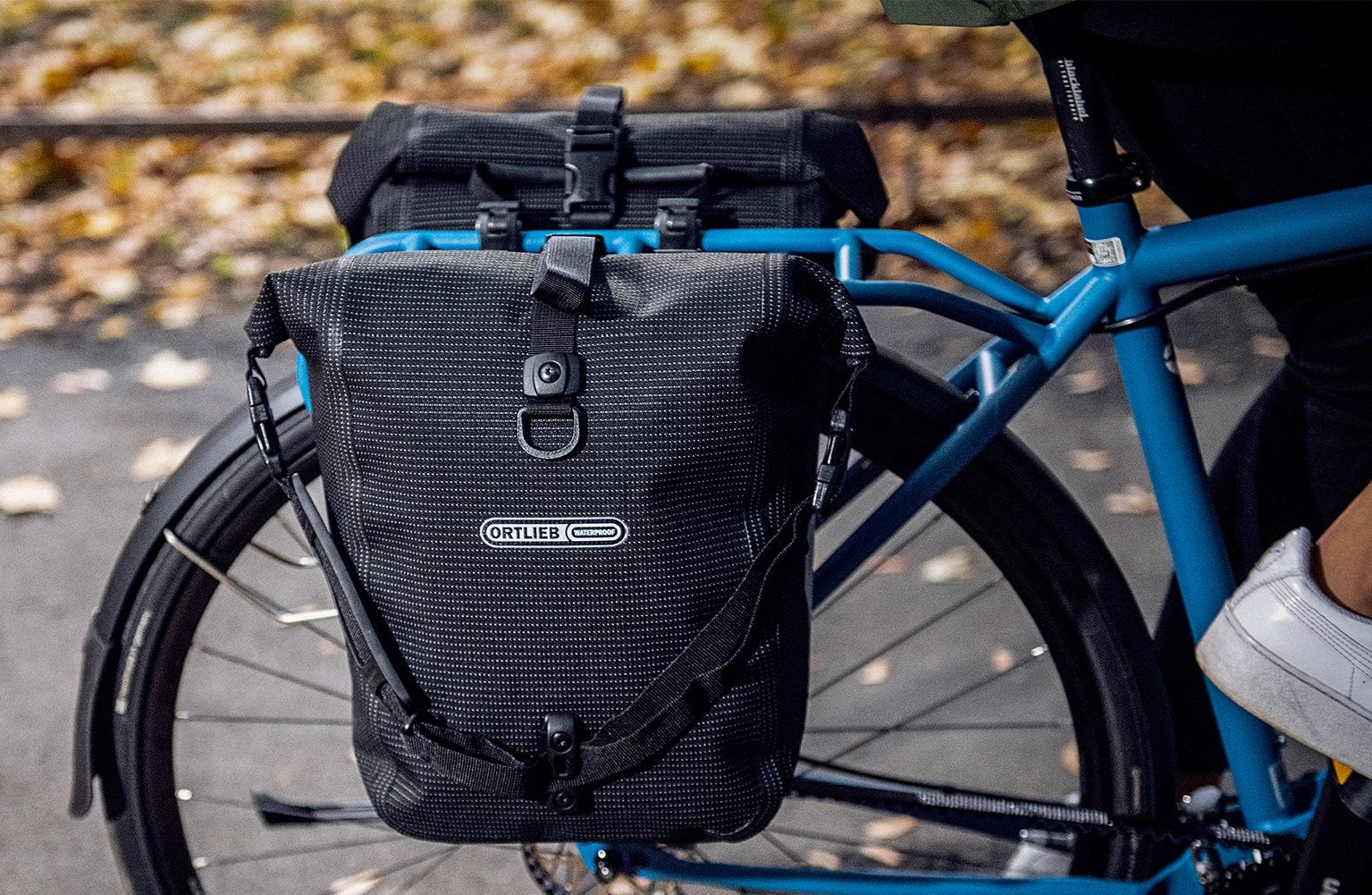 un velo bleu est equipe d'une paire de sacoches pour aller au travail
