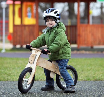 enfant sur draisienne en bois