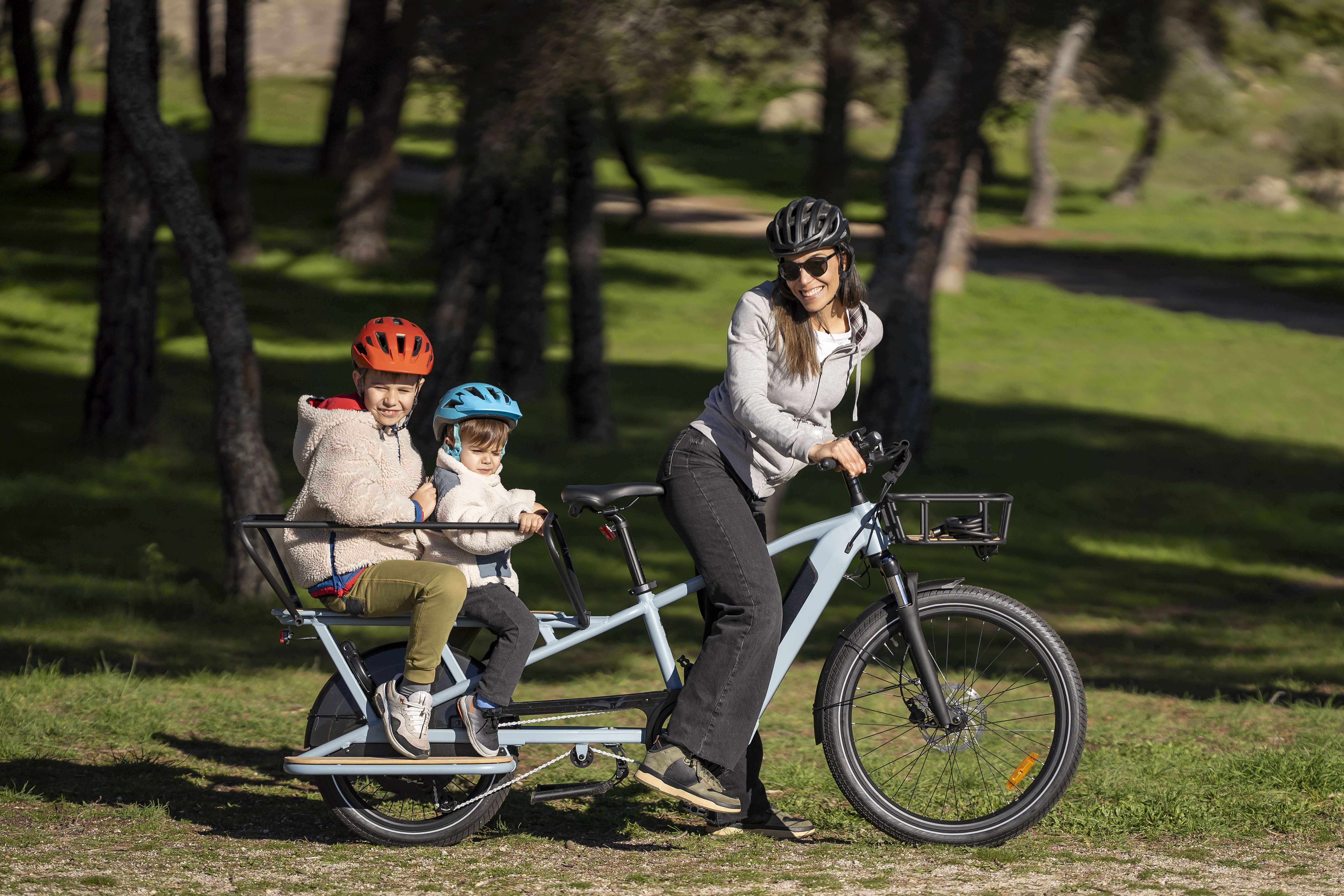 femme à vélo sur un longtail avec deux enfants à l'arrière