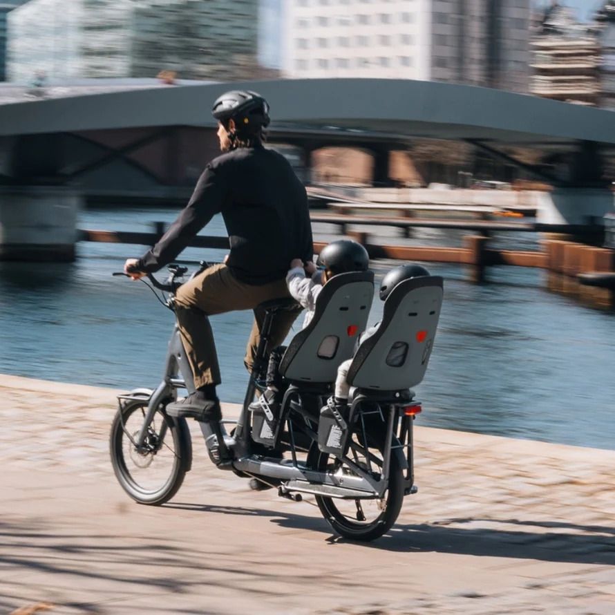 homme avec deux enfants sur un vélo longtail